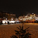 Jarmark bożonarodzeniowy ze straganami i choinką wieczorem